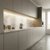 A modern kitchen with grey cabinets and a marble backsplash illuminated by a sleek, recessed mounted silver LED profile.