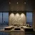 Recessed GU10 spotlight fixtures cast warm light onto a modern living room featuring a textured wall art and a large sectional sofa.