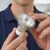 A person's hands are holding a Standard Halogen GU10 Par16 50W bulb. The bulb has a clear glass lens and a white base.